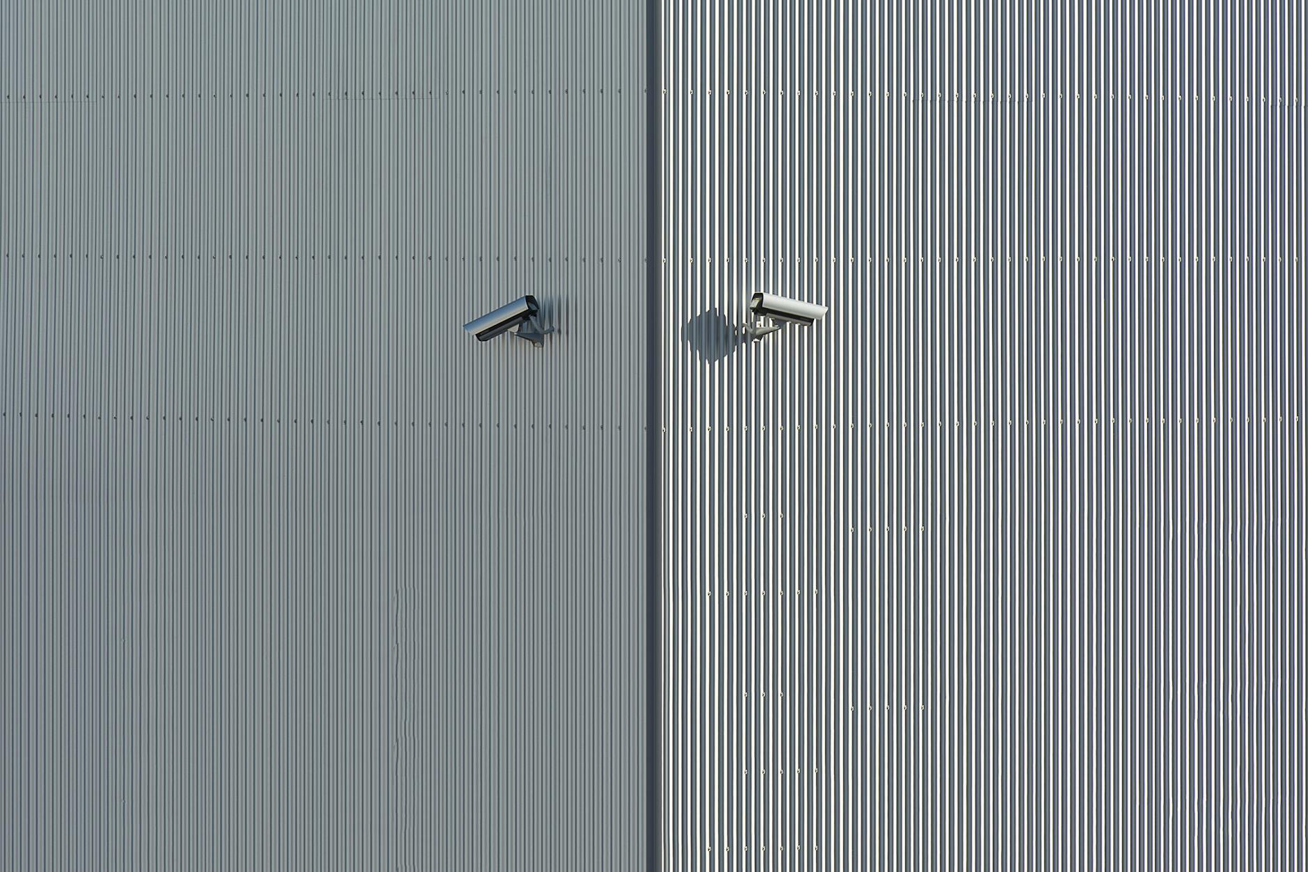 Dwie kamery monitoringu na metalowej ścianie w stylu minimalistycznym