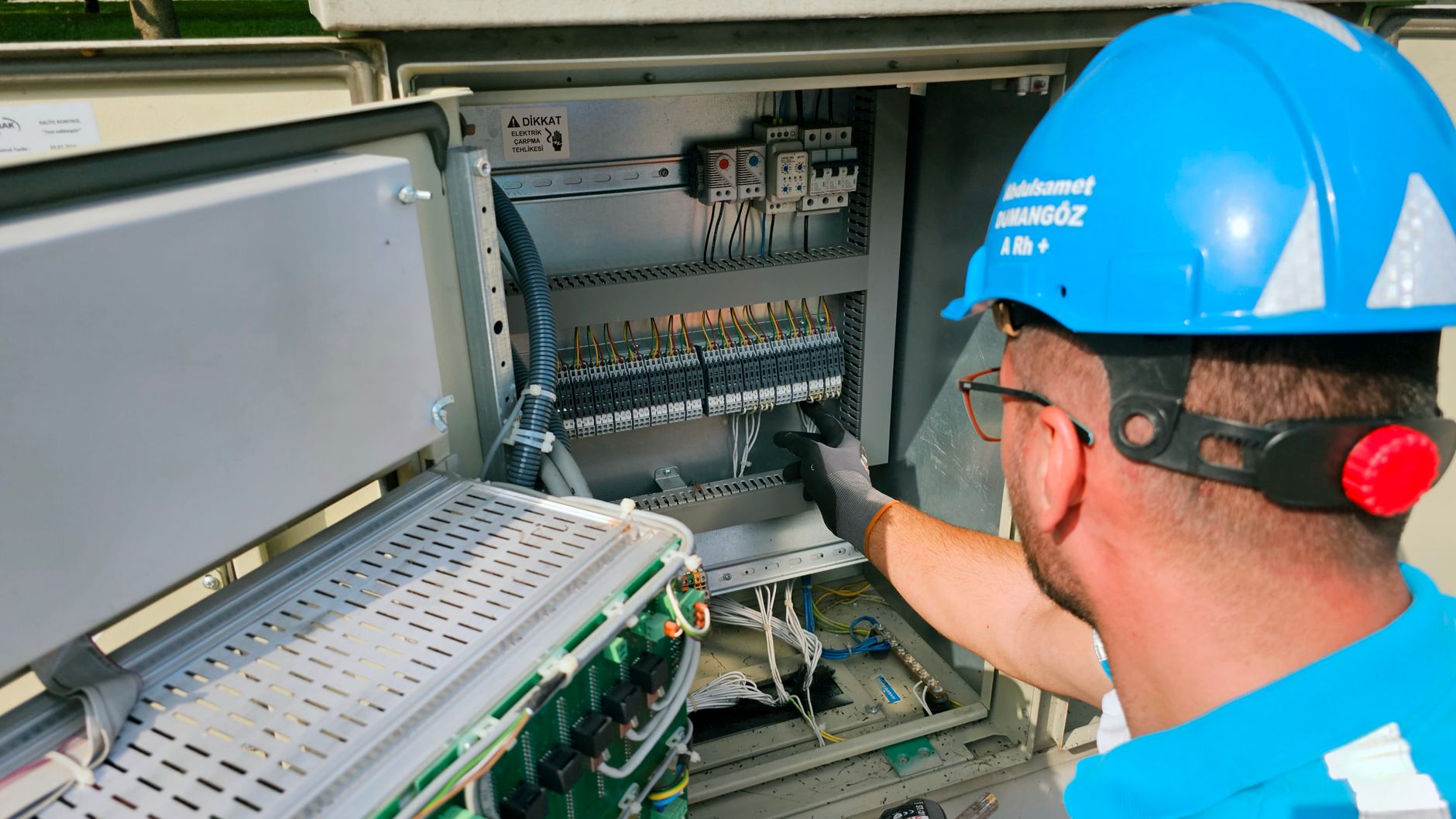 Elektryk pracuje przy zewnętrznej skrzynce bezpiecznikowej