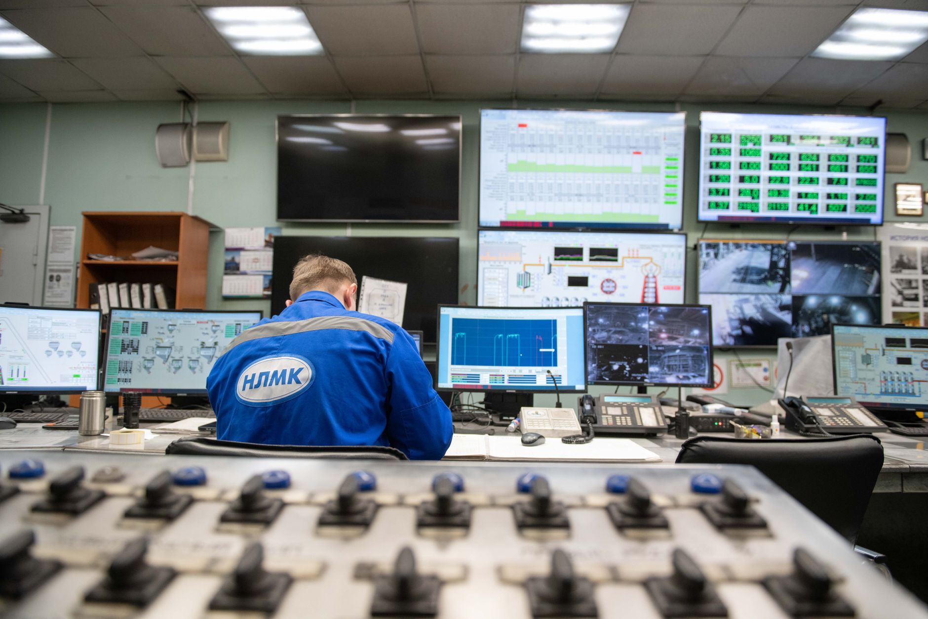 Inżynier monitoruje ekrany w przemysłowej sterowni SCADA